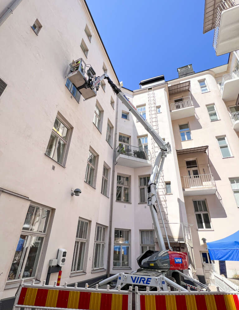 DINO-henkilönostin työskentelee rakennuksen sisäpihalla nostotöissä