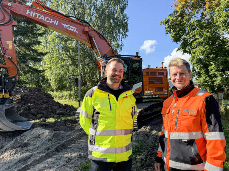 Sami Repo ja Rotatorin Vesa Lehto työmaalla Hitachi ZX225 -kaivinkoneen edessä.