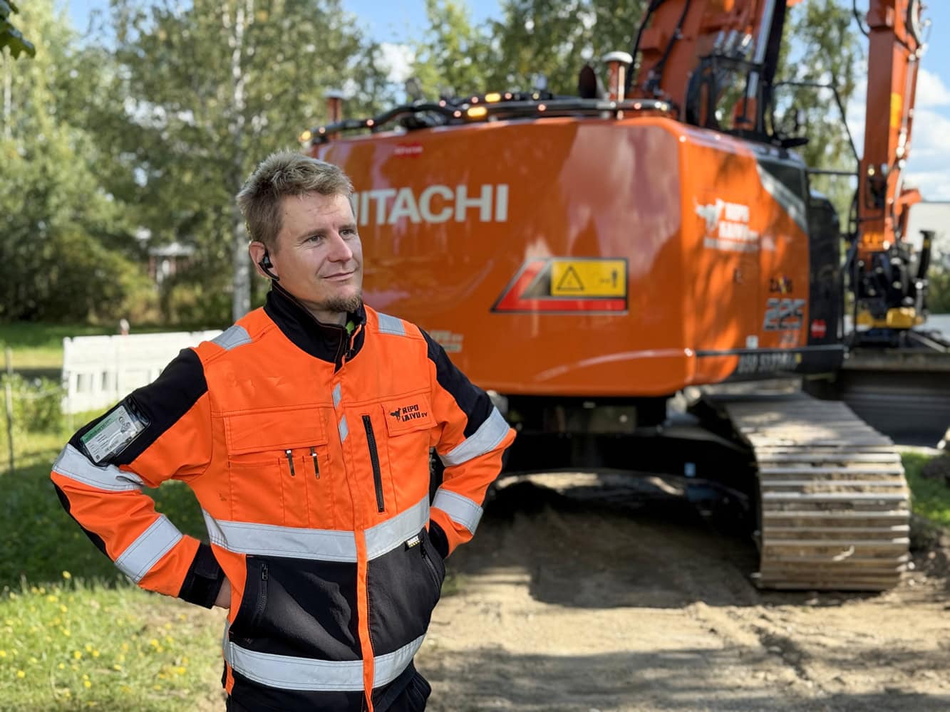 Repo Kaivu Oy:n omistaja Sami Repo työmaalla Hitachi ZX225 -kaivinkoneen edessä.
