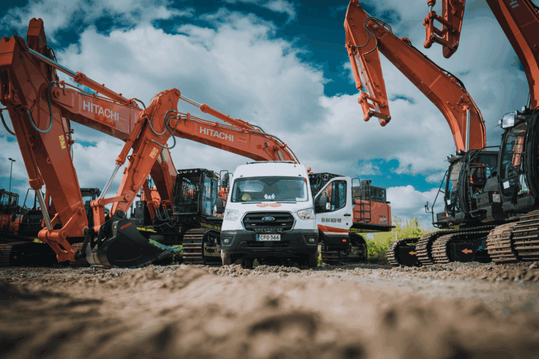 Hitachi-kaivinkoneita ja Rotatorin huoltoauto työmaalla kirkkaan taivaan alla.