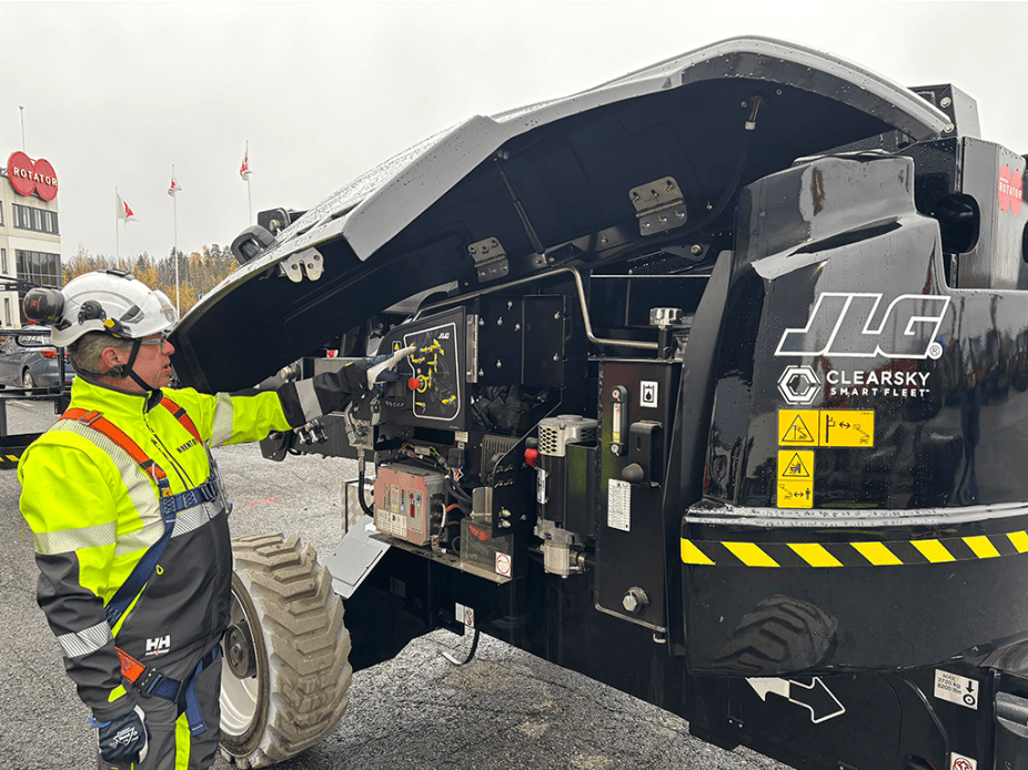 N Rentin työntekijä tarkistaa JLG EC520AJ -nostimen huoltopaneelia Rotatorin pihalla.