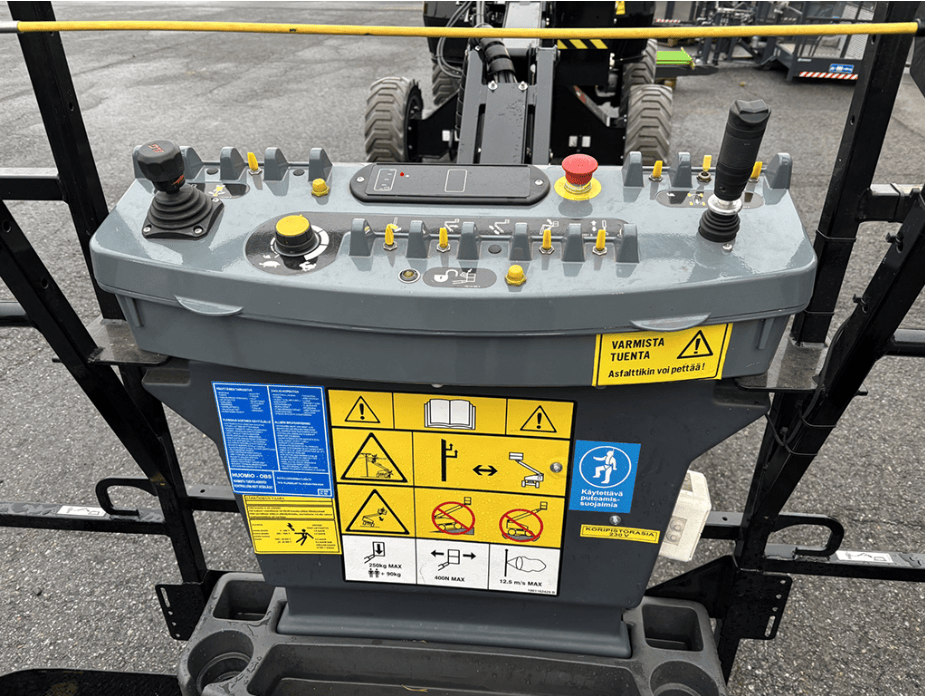JLG-nostimen korin ohjauspaneeli ja turvamerkinnät.
